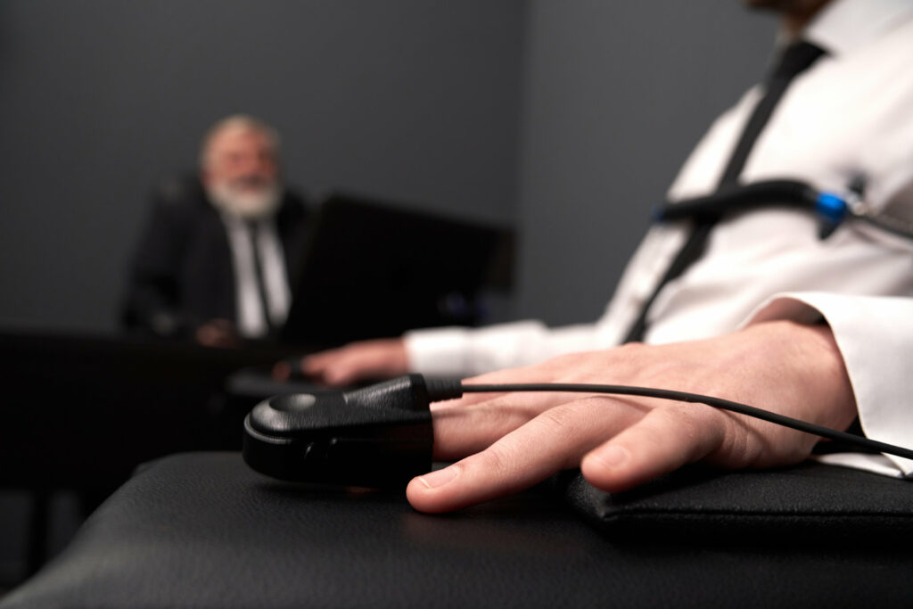 Close up of a finger sensor on a male undergoing a polygraph examination